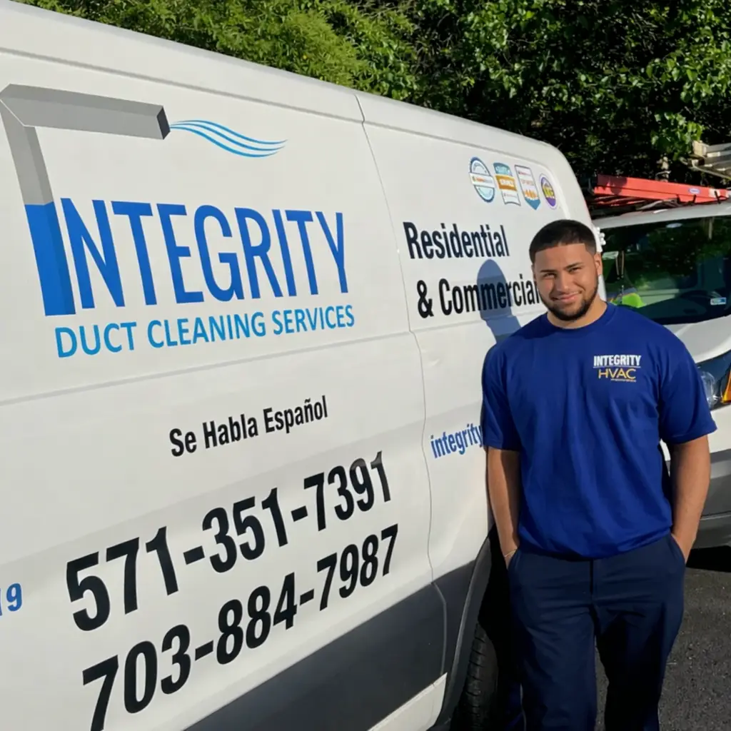Integrity Duct & HVAC technician standing beside white service van with company branding